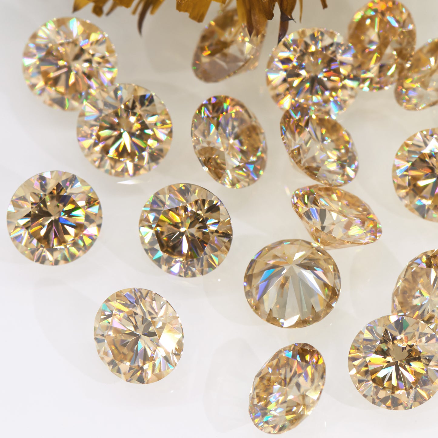 a collection of yellow round cut moissanite stones on off white background