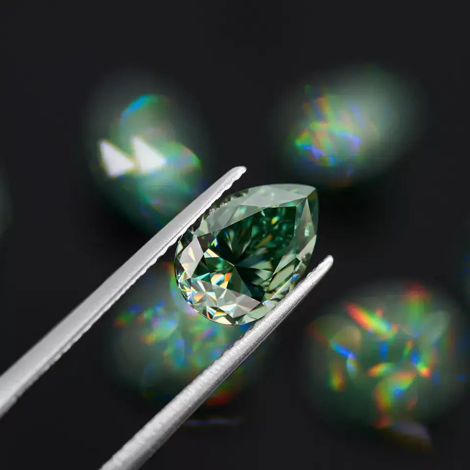 green pear cut moissanite stone in tweezers, bokeh black background with green stones