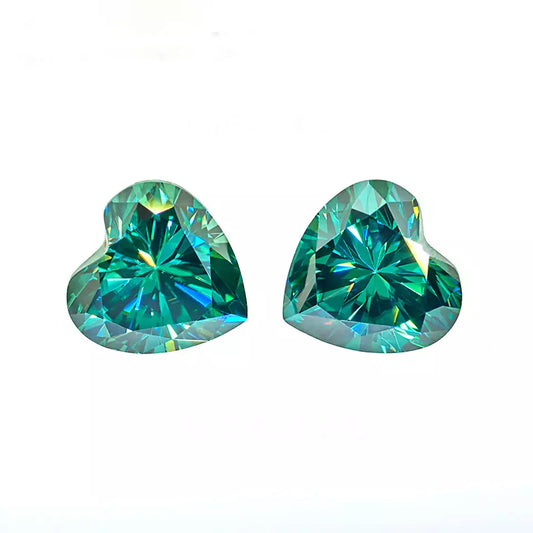 a pair of green heart cut moissanite stones on white background