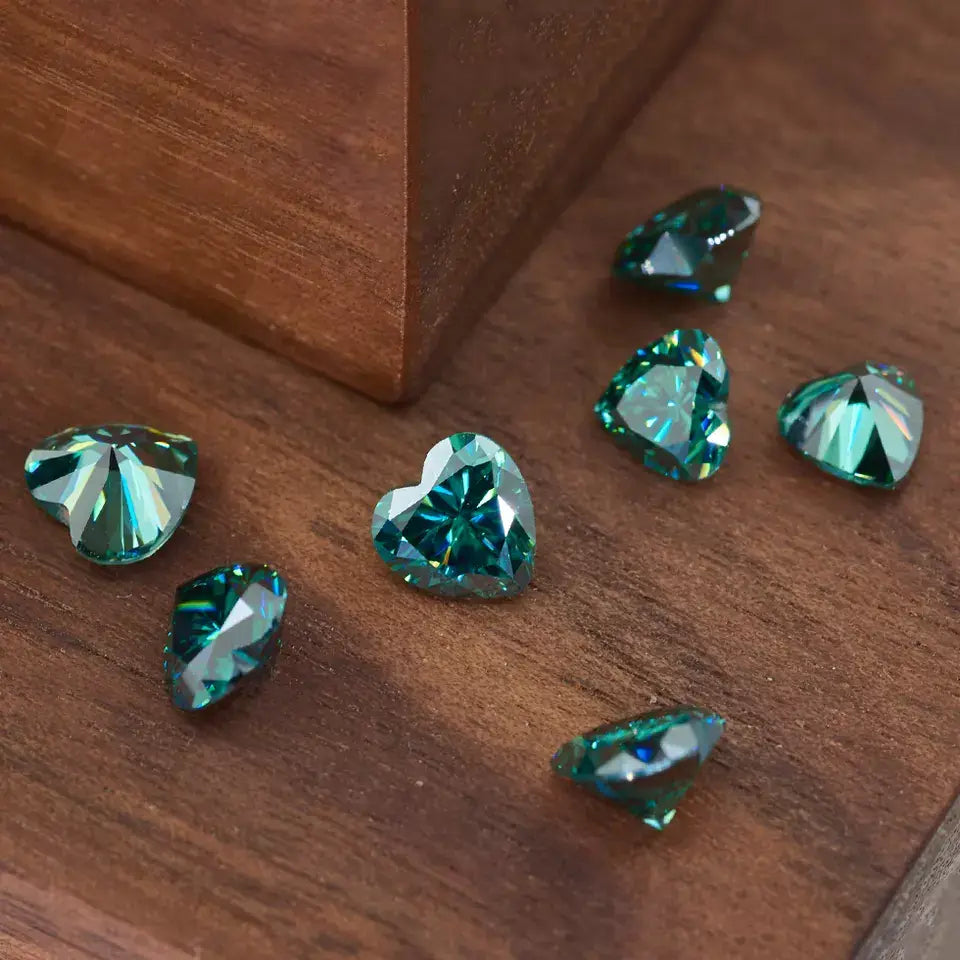 a collection of green heart cut moissanite stones on wooden background