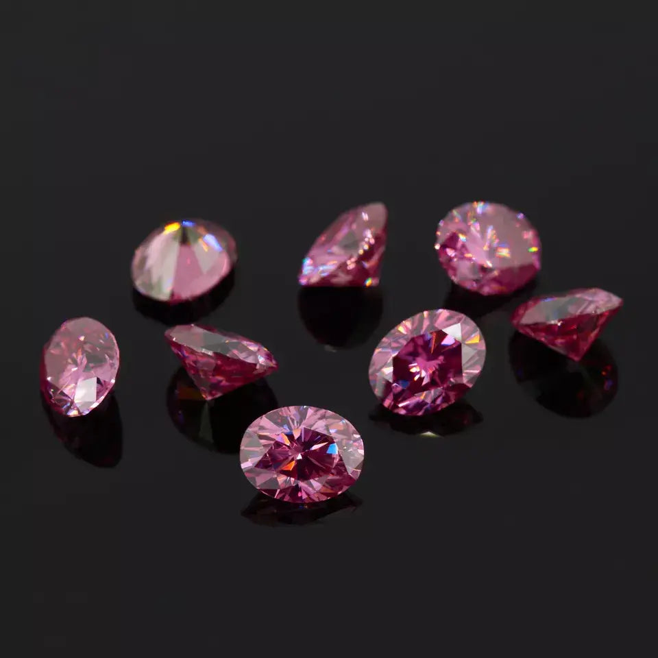 a collection of pink oval cut moissanite stones on reflective black background