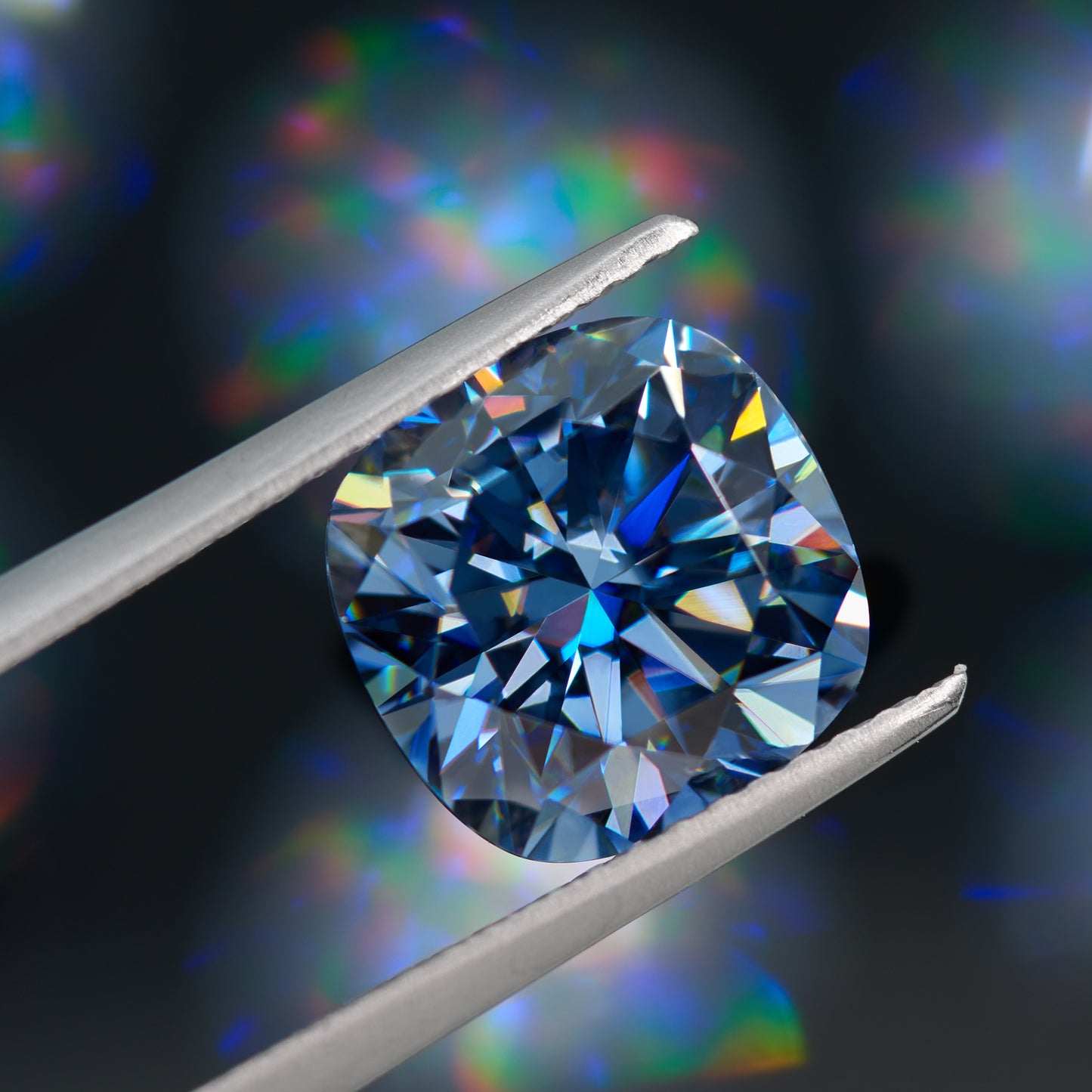 blue cushion cut moissanite stone betweez tweezers, black bokeh background with brilliant reflections