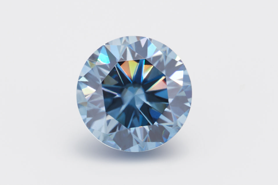 blue round cut moissanite stone on light grey background