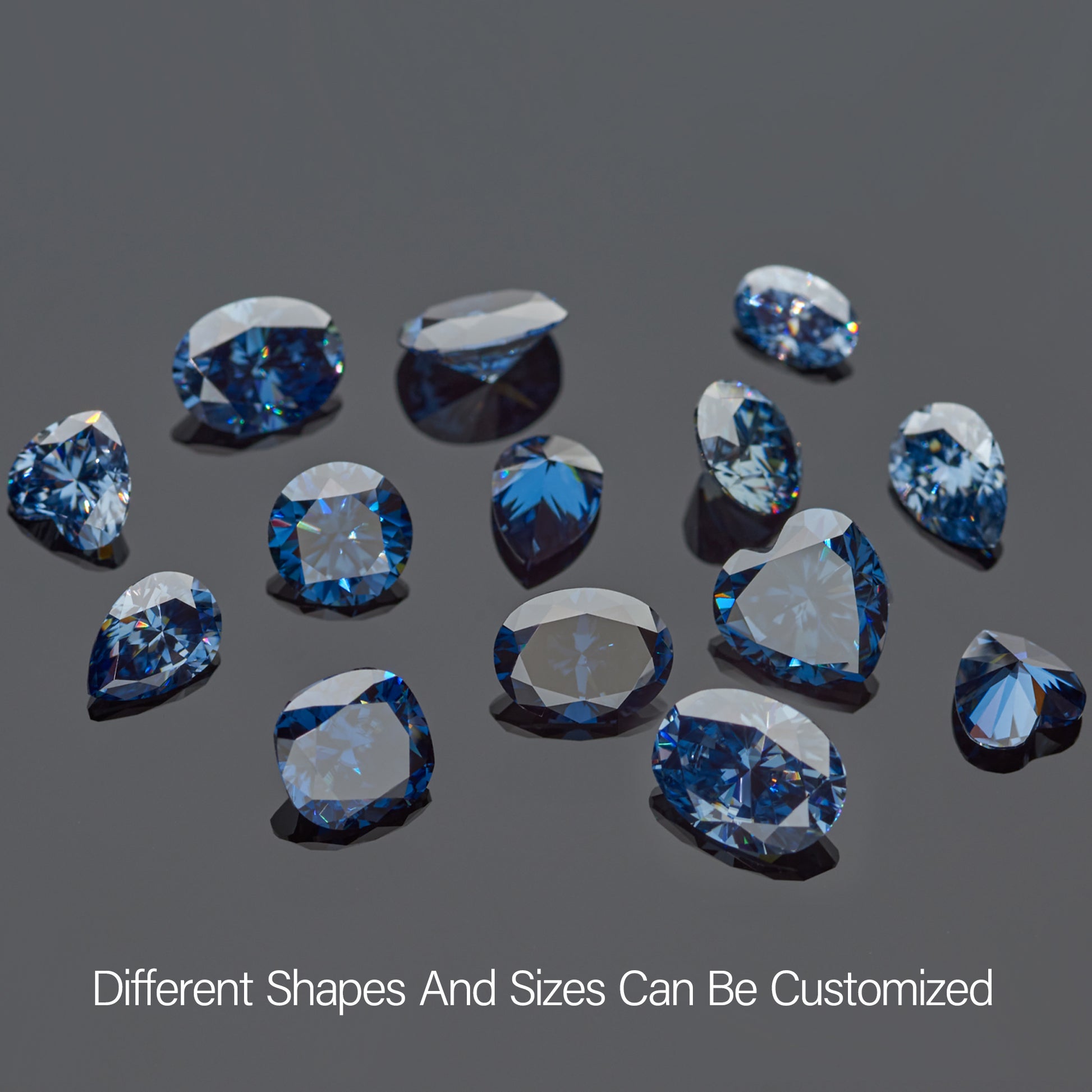 a collection of dark blue moissanite stones on grey background, round cut, pear cut, heart cut, oval cut