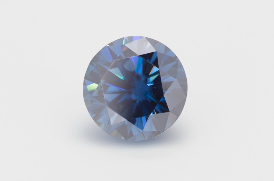 dark blue round cut moissanite stone on light grey background