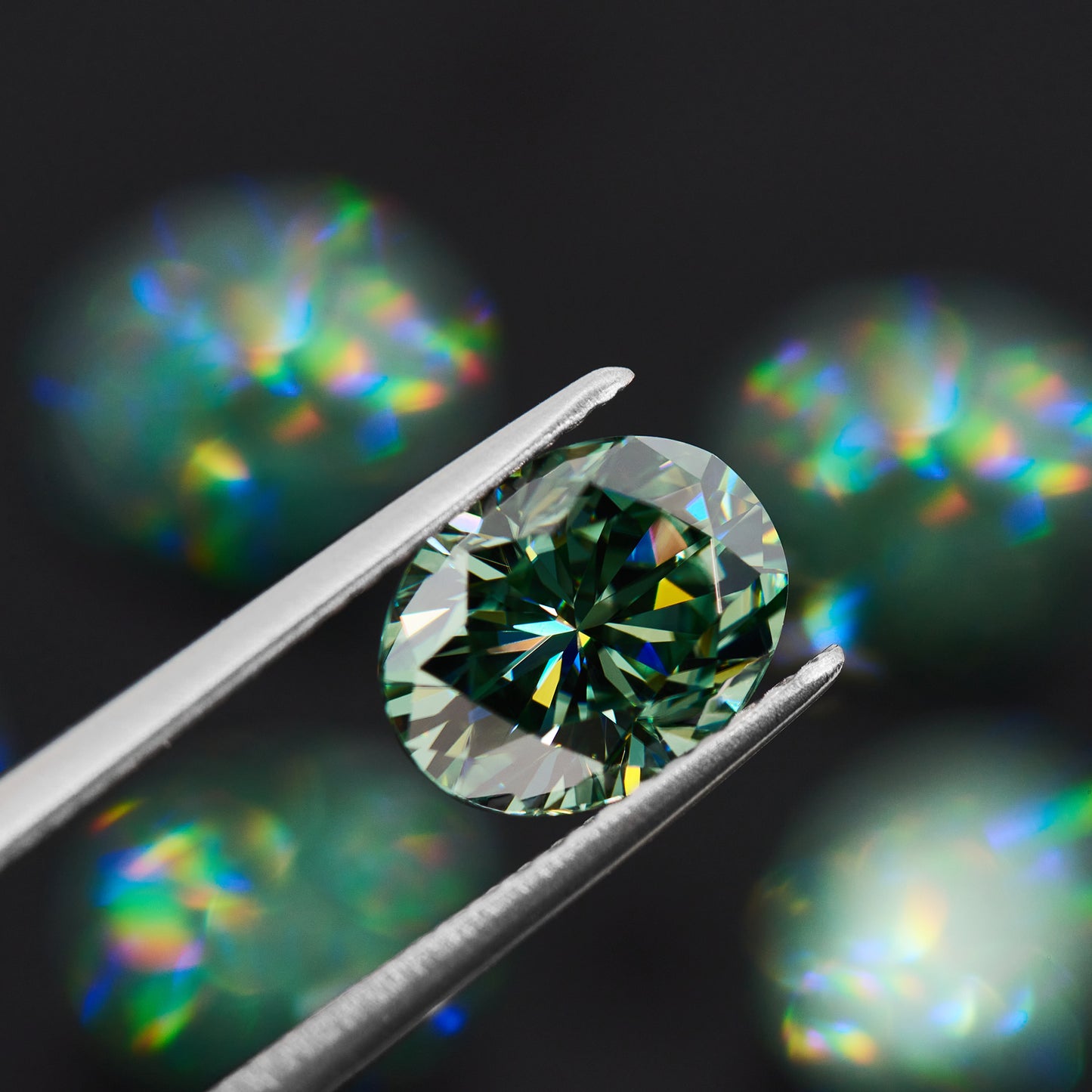 green oval cut moissanite stone in tweezers on black bokeh background with several other green stones