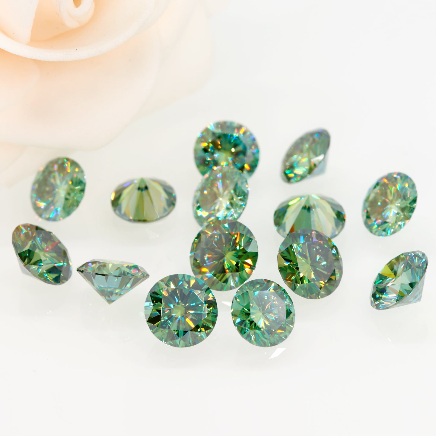 a collection of green round cut moissanite stones on white background