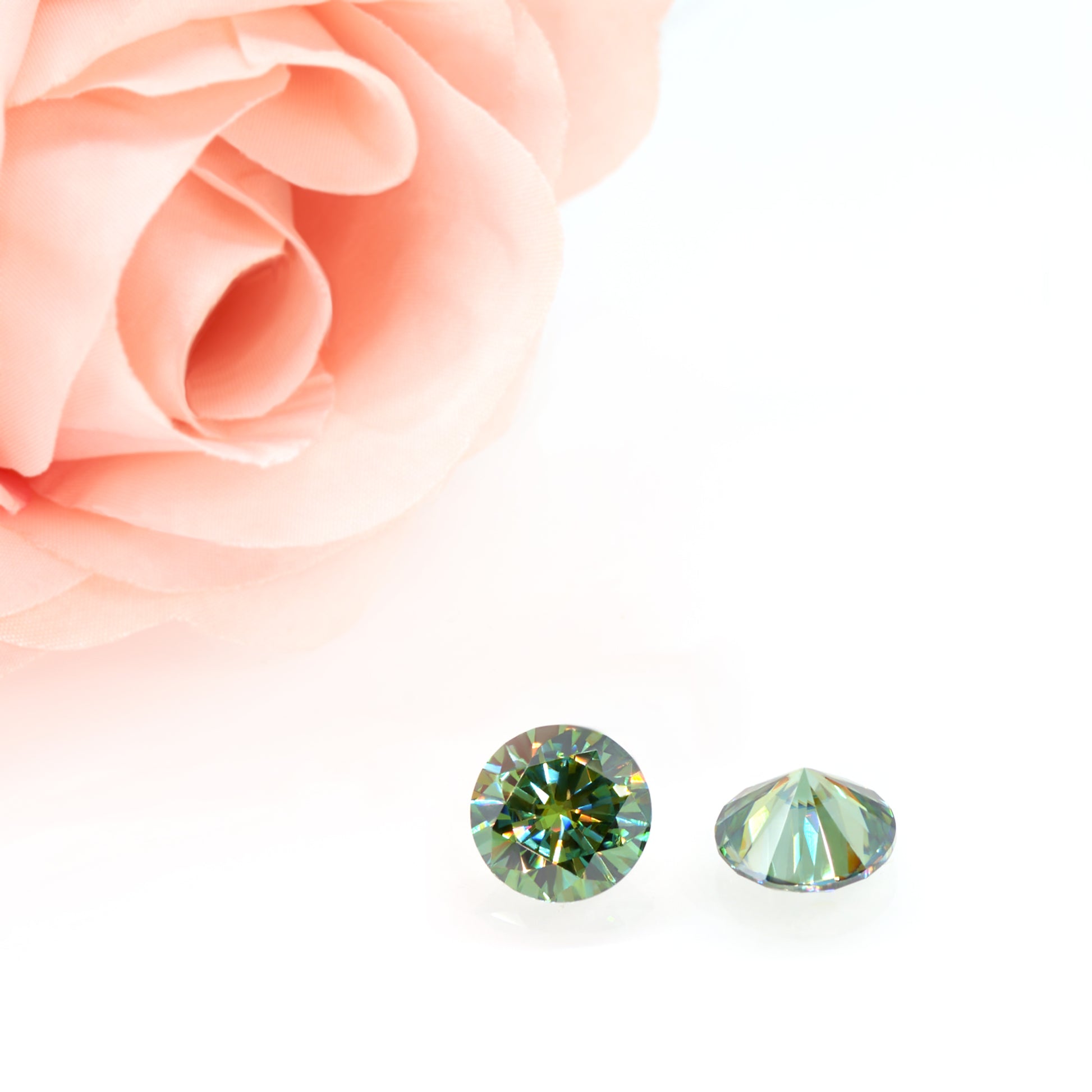 a pair of green round cut moissanite stones on white background