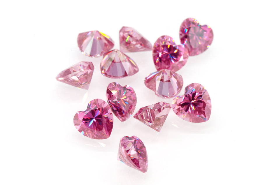 a collection of pink heart cut moissanite stones on white background