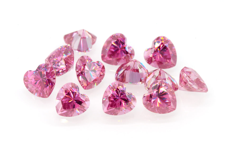 a collection of pink heart cut moissanite stones on white background