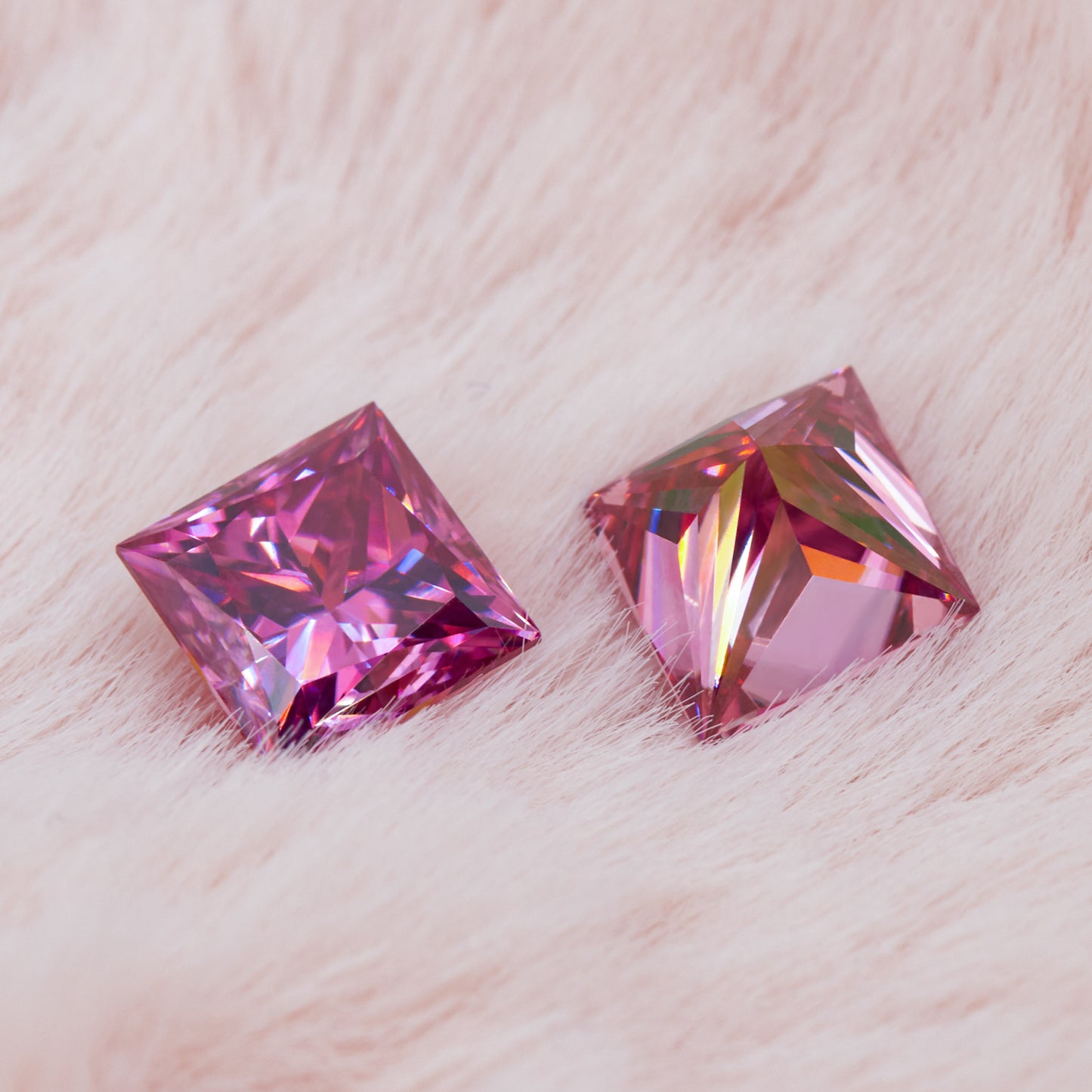 a pair of pink princess cut moissanite stones on a light pink fur background