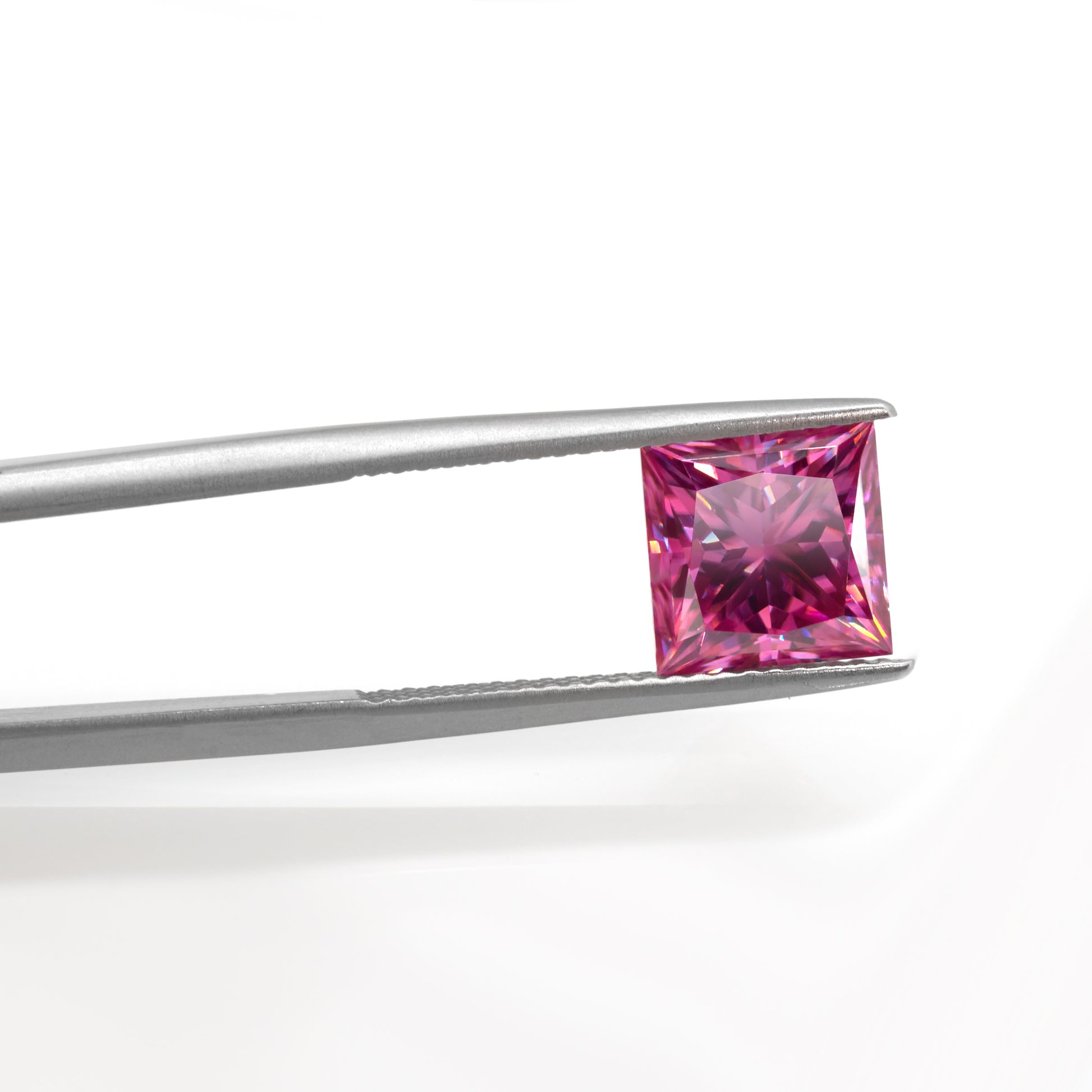 pink princess cut moissanite stone between tweezers