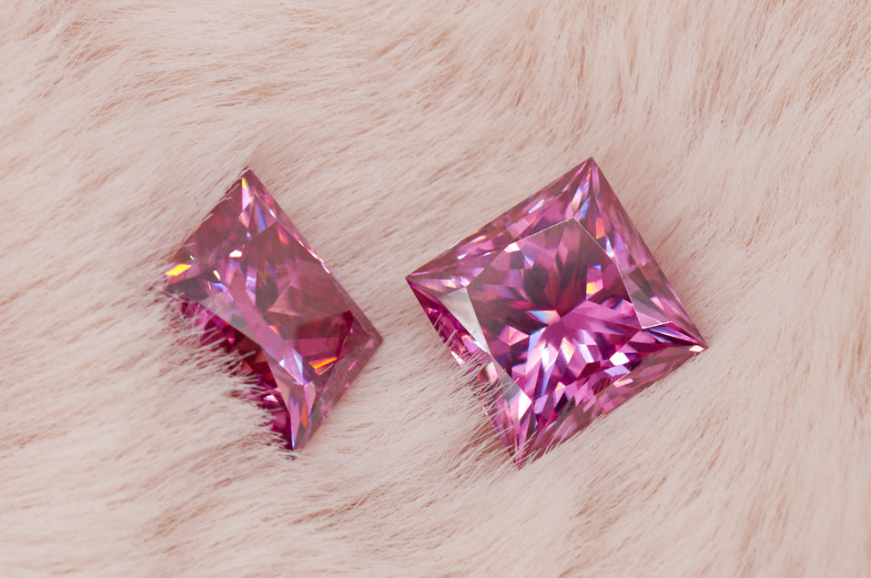 a pair of pink princess cut moissanite stones on light pink fur 