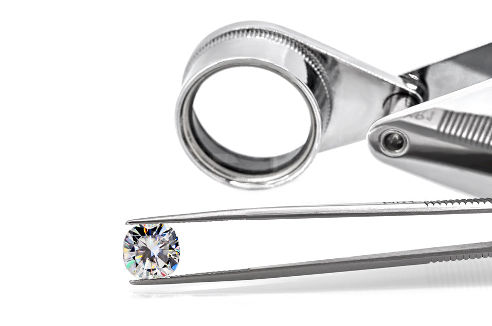 white cushion cut moissanite stone between tweezers, beautiful internal reflections