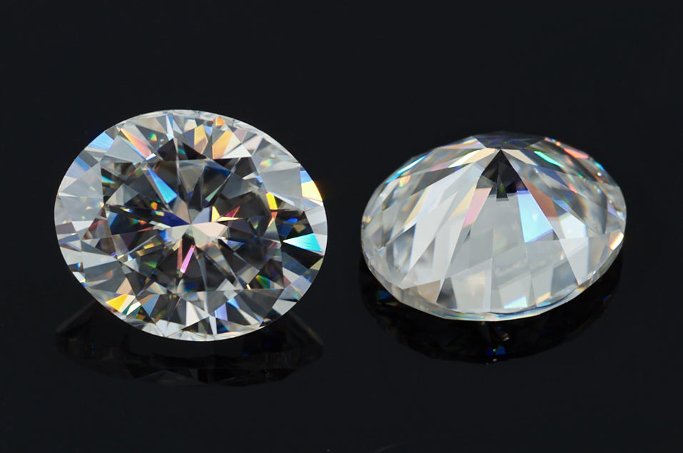 a pair of white oval cut moissanite stones on black background, brilliant internal reflections