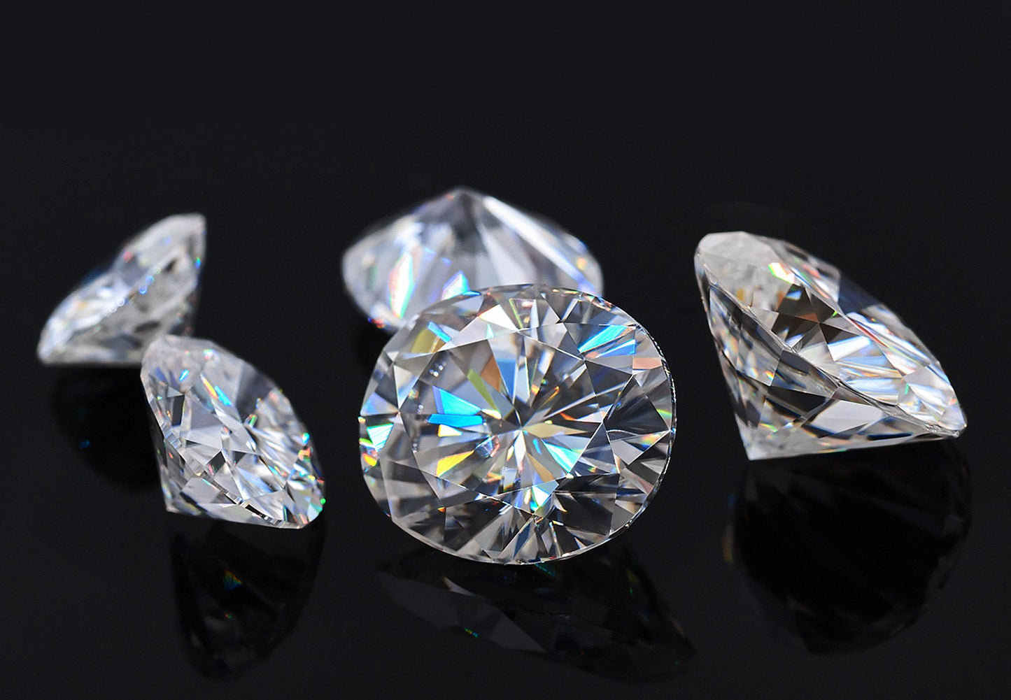 a collection of white oval cut moissanite stones on black background