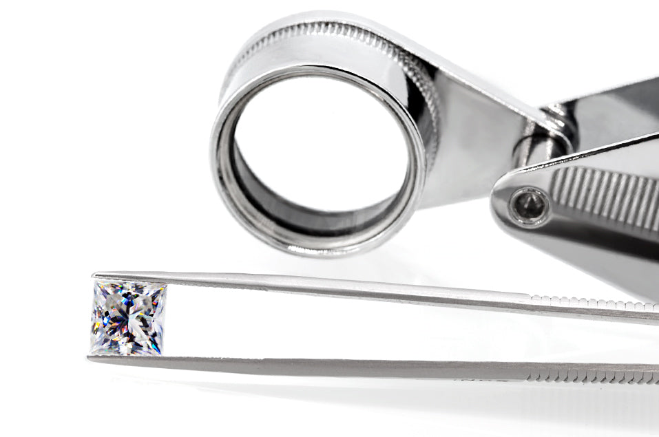 white princess cut moissanite stone between tweezers