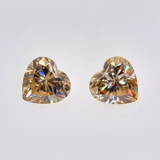 a pair of yellow heart cut moissanite stone on off white background